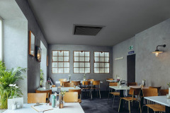 View of empty sitting room in industrial chic cafe with wooden chairs, Cologne, NRW, Germany