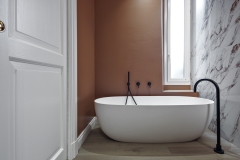 Modern bathroom interior with a freestanding bathtub and wooden flooring in the foreground                 Project architeto Laura Pegazzano