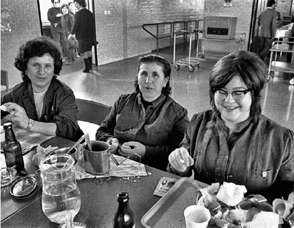 Foto in bianco e nero di alcune operaie riprese durante il pranzo alla mensa operaia nello stabilimento Fiat di Rivalta, maggio 1972 foto Mauro Vallinotto