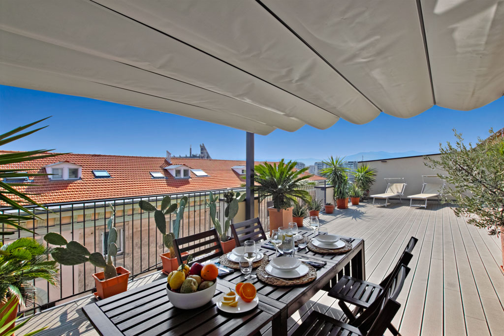 terrace with dining area with wooden floor with views on the roofs of La Spezi