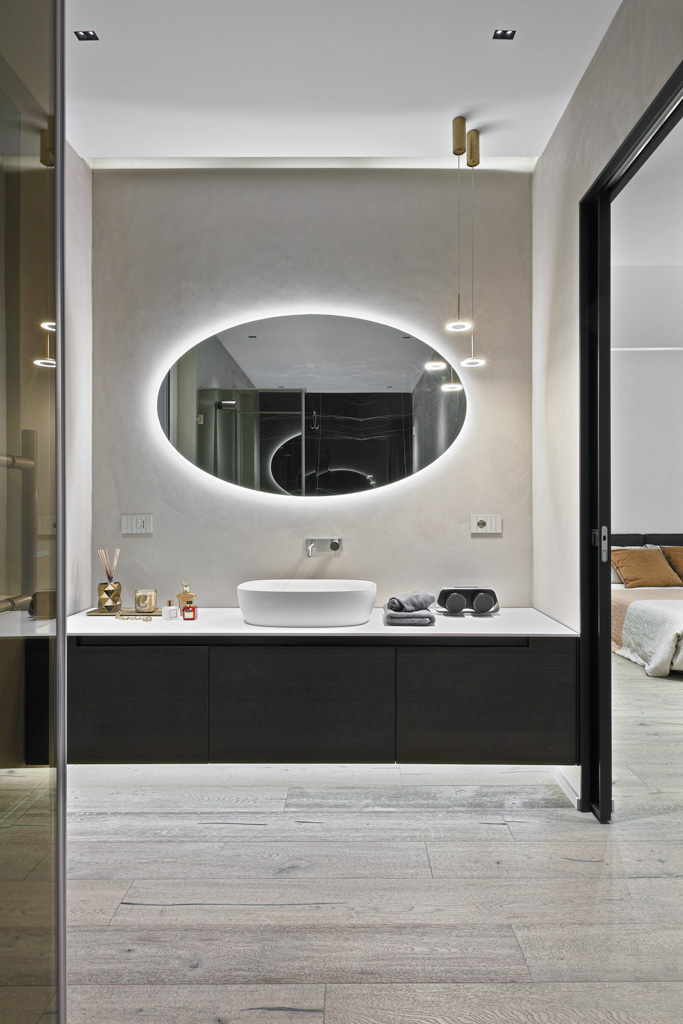 Luxury bathroom vanity unit on wooden floor in open-plan bedroom
